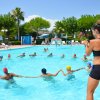 Lezione di nuoto in piscina con persone in cerchio.
