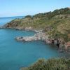 Una costa rocciosa con mare blu e vegetazione verde sulle scogliere.