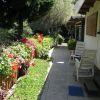 Sentiero affiancato da fiori e sedie da giardino.