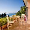 Terrazza con tavolo, sedie e vista mare.