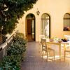 Cortile con tavolo, sedie e ingresso ad arco.