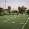 Campo sportivo all'aperto con erba artificiale e reti.