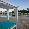 Piscina con lettini bianchi e tendaggi.