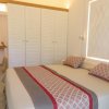 Interno di una camera con letto matrimoniale e armadio bianco.