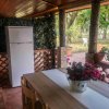 Frigorifero e tavolo con fiori su veranda.