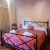 Camera da letto con letto matrimoniale, coperte arancioni e armadio.