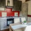 Cucina con forno, fornelli, tavolo e sedie.