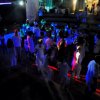 Folla che balla in discoteca con luci colorate.