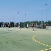 Campo sportivo all'aperto con persone che giocano a calcio.
