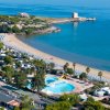 Piscina e spiaggia affollate.