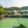 Campo da tennis circondato da alberi.