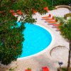 Piscina circolare con lettini arancioni.
