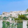 Vista città su collina, balaustra con muro blu.