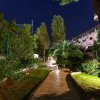 Sentiero illuminato tra alberi e cespugli di notte.