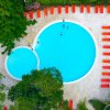 Piscina dall'alto con lettini rossi intorno.