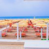 Spiaggia con ombrelloni e lettini arancioni.