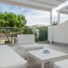 Terrazza moderna con divani bianchi e piante.