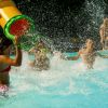 Bambini che giocano in piscina con schizzi d'acqua.
