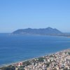 Vista aerea di una costa con spiaggia e montagna in lontananza.