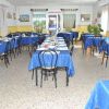 Sala da pranzo con tavoli coperti da tovaglie blu.