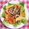 Fritto misto di pesce e gamberi su lattuga con limone.