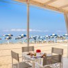 Tavolo con colazione in spiaggia, ombrelloni blu.