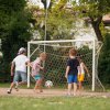 Bambini giocano a calcio vicino a una porta.