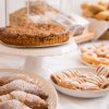 Dolci assortiti su un tavolo, inclusi ciambelle e torte.