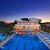 Edificio illuminato con piscina al tramonto.