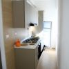 Cucina stretta con arredi moderni e frigorifero.
