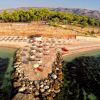 Veduta aerea di una spiaggia con ombrelloni e pietra frangiflutti.