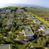 Villaggio di bungalow immerso tra ulivi e vicino al mare.