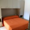 Camera con letto matrimoniale e copriletto arancione.