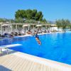 Persona tuffa in piscina blu.