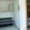 Soggiorno con divano blu e camera da letto adiacente.