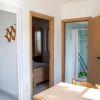 Cucina e corridoio con porte aperte verso una stanza e un bagno.