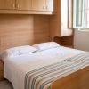 Camera da letto con letto matrimoniale e armadi in legno chiaro.