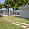 Giardino con vialetto in pietra e edifici bianchi.