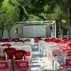 Sedie rosse e bianche all'aperto con palco.