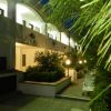 Cortile illuminato con vegetazione e edificio moderno.