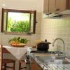 Cucina con finestra aperta, verdure sul tavolo.