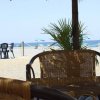 Sedie di vimini su una spiaggia con ombrelloni e vista sul mare.