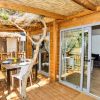 Terrazza coperta con tavolo e sedie accanto ad alberi.