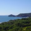 Costa con mare e colline verdi.