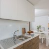 Cucina moderna con mobili bianchi e legno.
