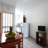Cucina con tavolo da pranzo, TV e piatto di frutta.