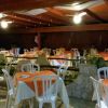 Sala da pranzo con tavoli apparecchiati e sedie bianche.