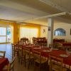 Interno di ristorante con tendaggio giallo e tavoli apparecchiati.
