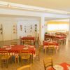 Sala da pranzo con tavoli apparecchiati e sedie di legno.