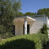 Casa bianca con pilastri, circondata da verde.